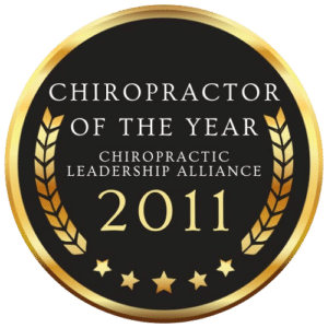 Gold and black badge with the text 'Chiropractor of the Year - Chiropractic Leadership Alliance 2011,' featuring laurel wreaths and stars.