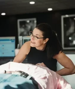 Woman with glasses offering chiropractic care in a modern wellness clinic, showcasing professionalism and personal attention.