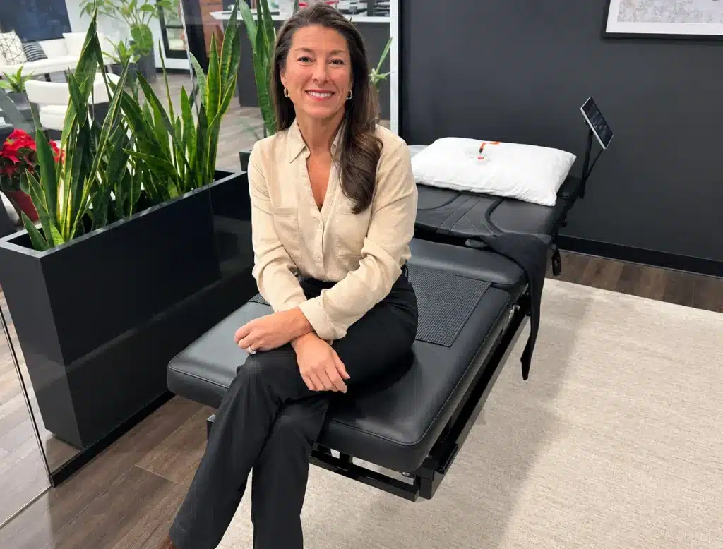 Dr. Cherine seated on the HillDT spinal decompression table at HFC Wellness in Glen Allen, VA